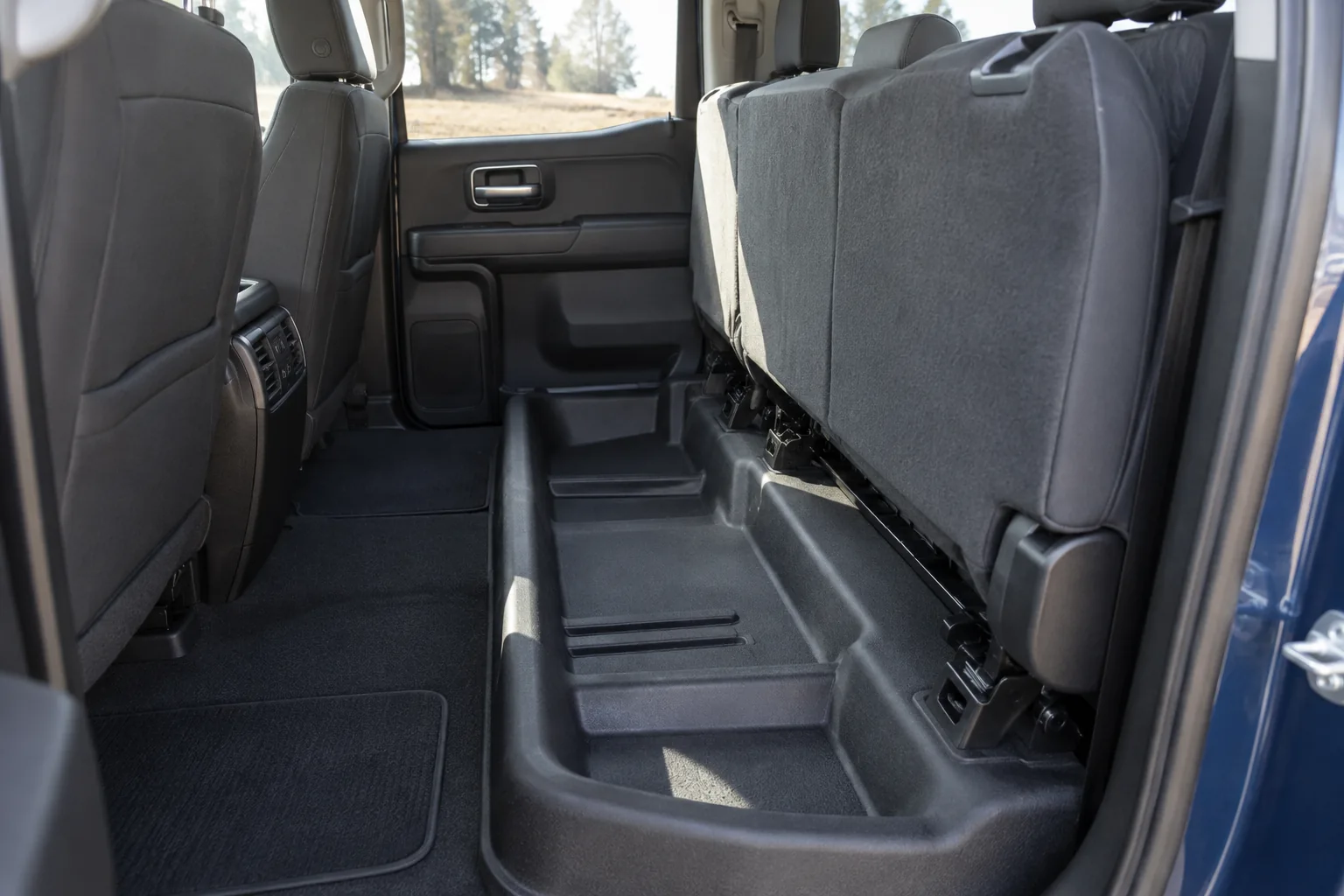 Empty space beneath the folded rear bench of a pickup